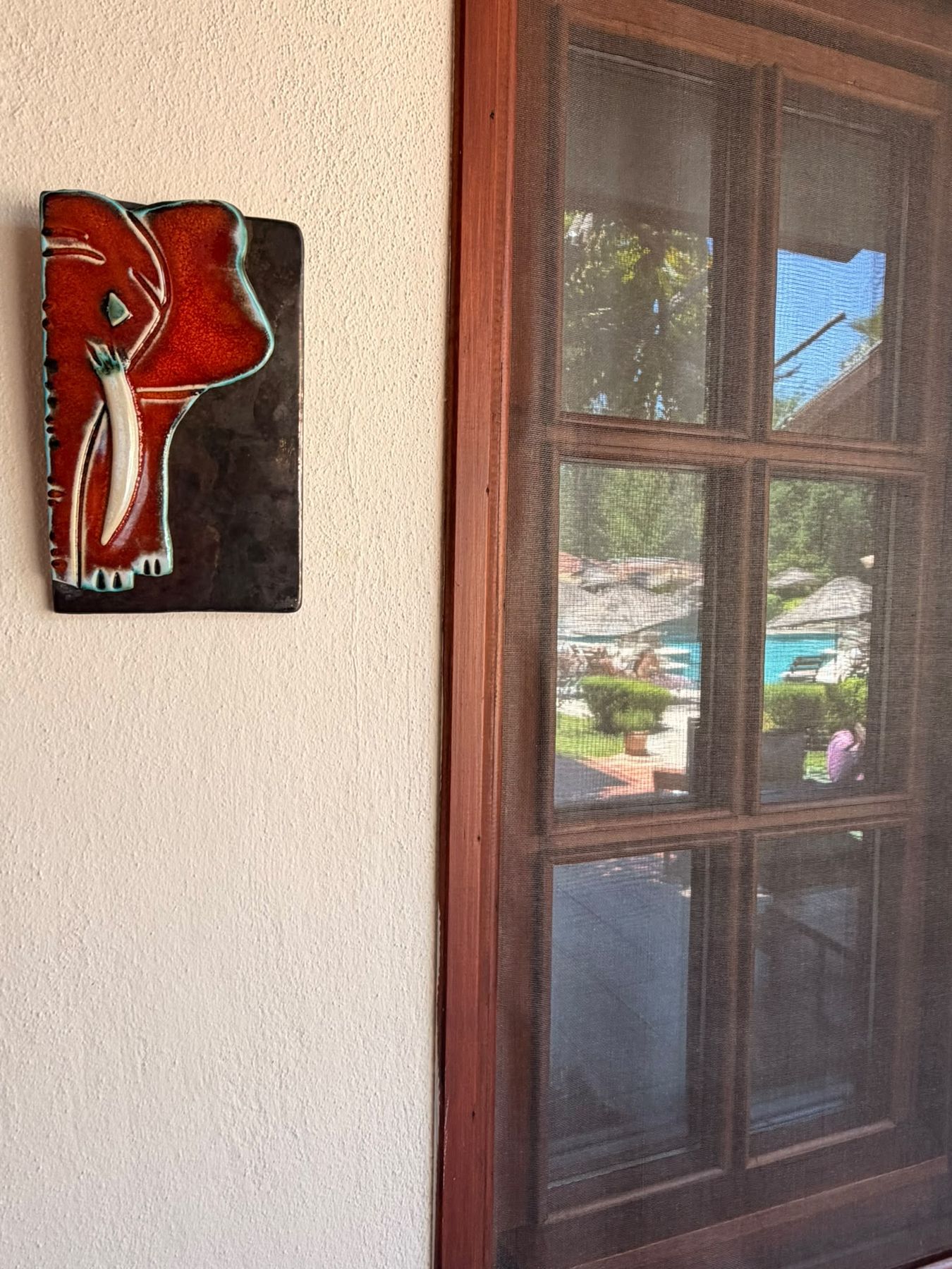 Keramik-Kunstwerk neben einem Holzfenster der Grenadine Lodge
