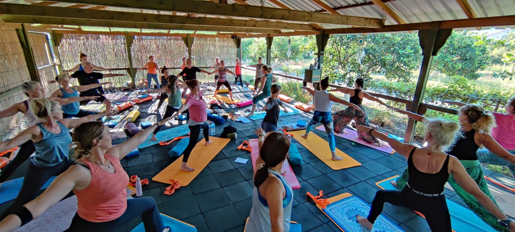 Offenes Yoga-Studio mit Bambuswänden und Blick in den Obstgarten